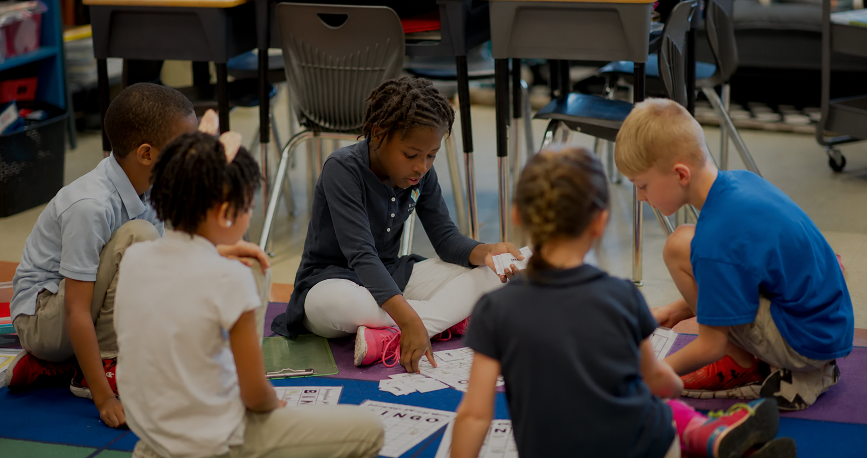 Students playing a word game together on the classroom rug